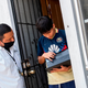 David Palencia from JFK helps Angel, 13, to connect his computer to the Wifi Hotspot provided by a parked van from JFK Transportation in order to follow his online classes, September 16, 2020, in Santa Ana, California.
